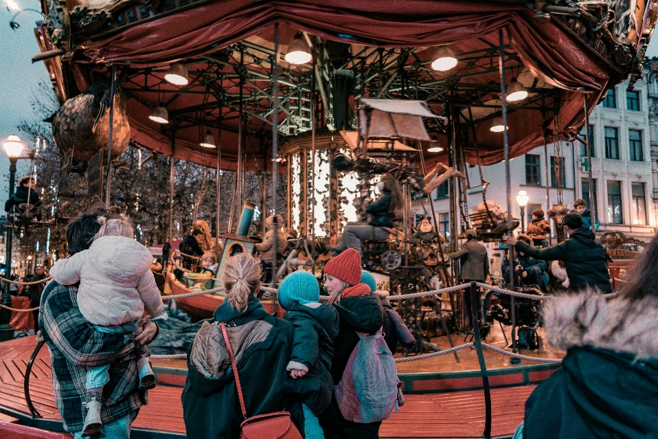 A group of people standing around a merry go round