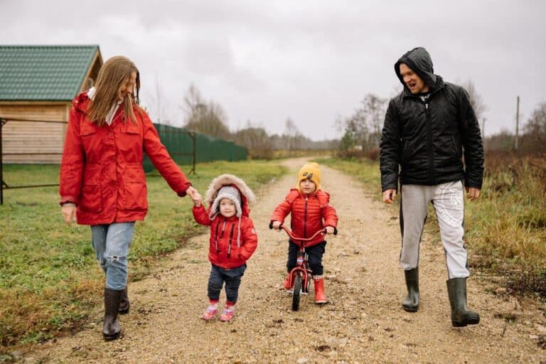 Man and woman with their kids walking on a village road